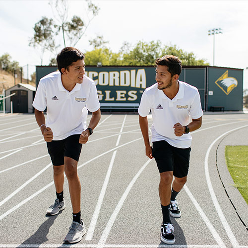 The Aguirre brothers sitting in front of the Concordia Eagles sign